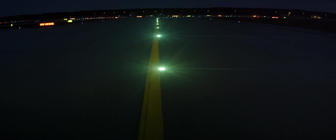 Green lights on airport runway at night