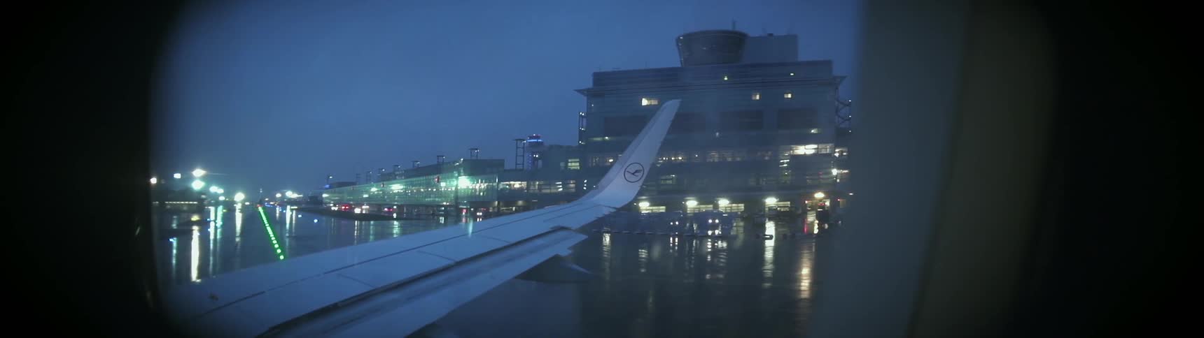 The plane is landing on the runway as it rains