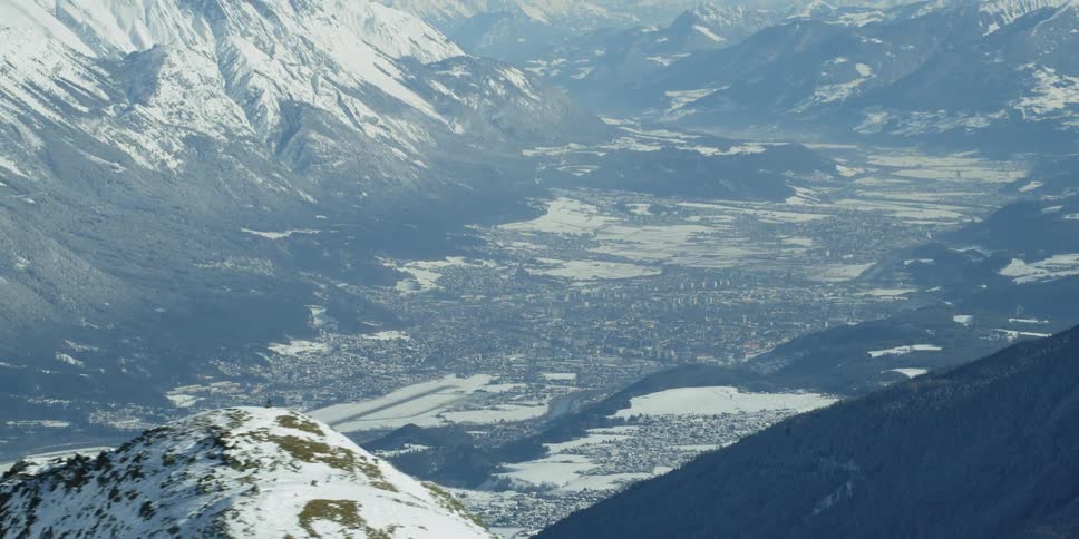Snow covers mountains in the wilderness with Innsbruck in the background