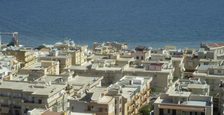 Houses and buildings in city next to ocean on sunny day