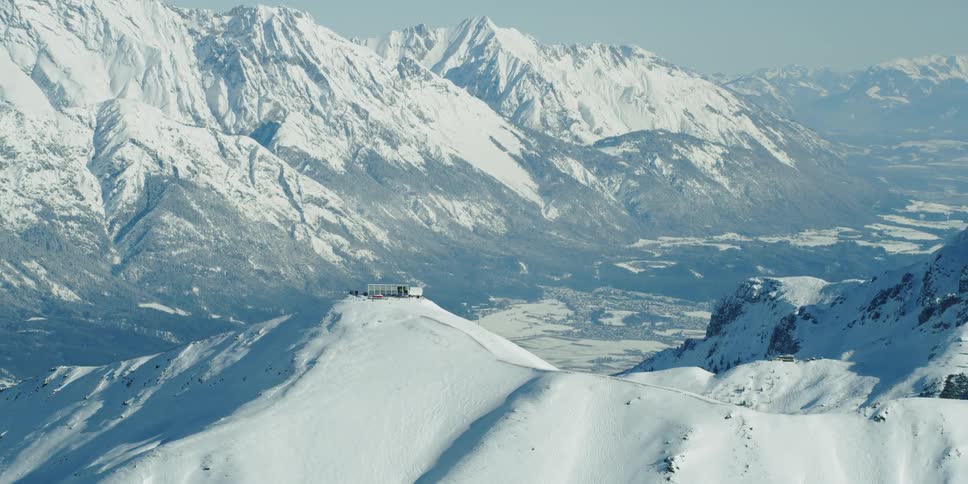 The Axamer Lizum ski resort with Innsbruck in the background sits on a snowy mountain peak