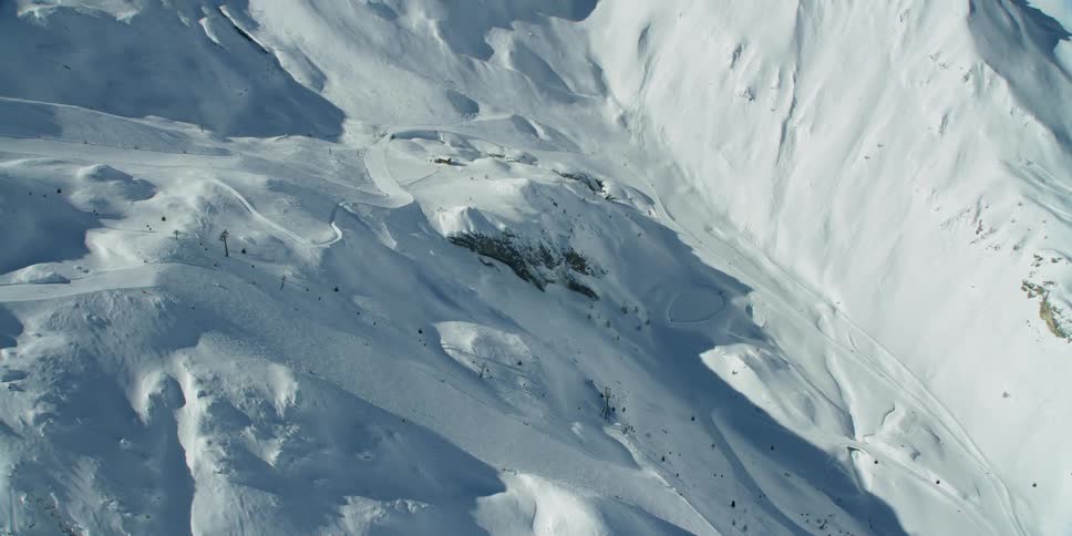 Ski lift on snow covered mountain on sunny day