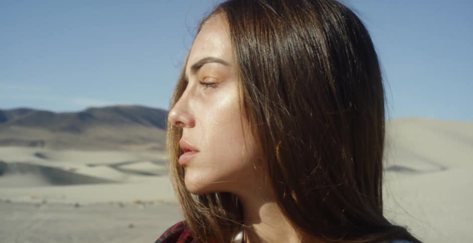 A woman looks out over the desert on a sunny day