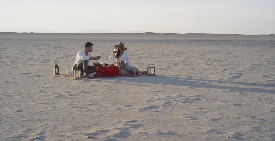A man and woman picnic in a desert