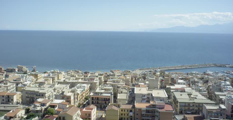 Houses and buildings in city next to ocean on sunny day