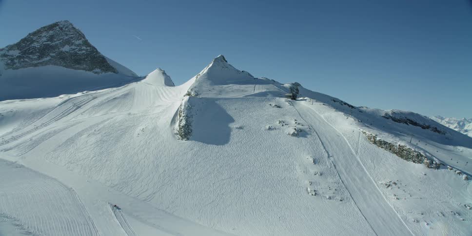 Snow-covered hills with ski slopes on clear day