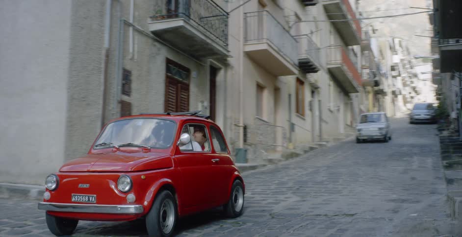 Cars travel down cobble stoned village roads