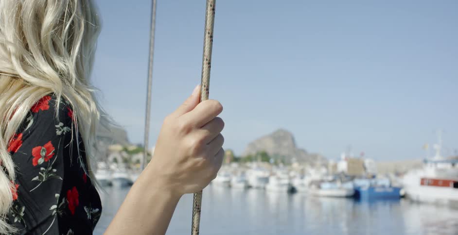 A woman hold onto a rope line on a boat