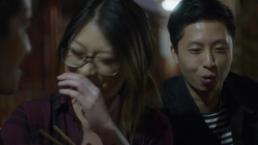 Group of people smiling and eating outside at night