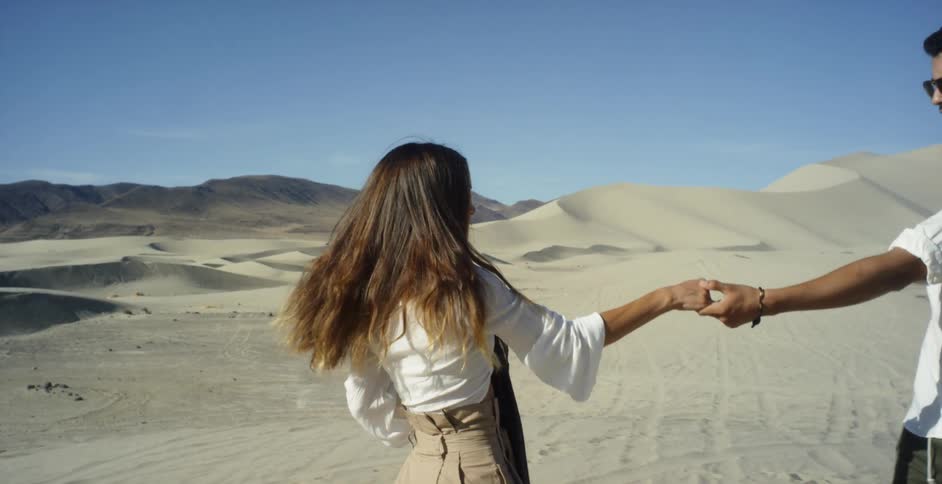 A man and woman dance in a desert