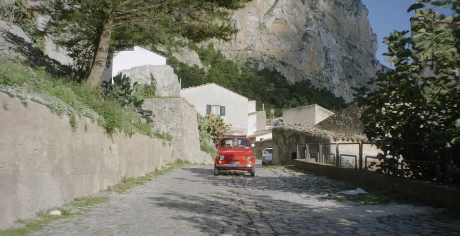 A car travels on a stone road on a sunny day
