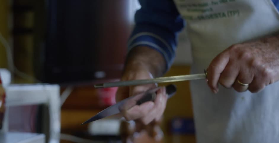 Person sharpens a knife on a honing steel