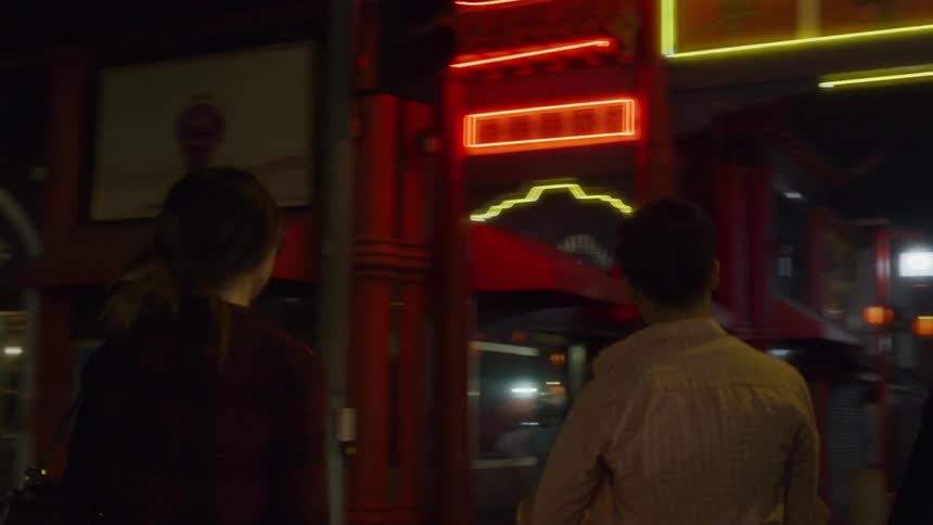 A group of friends are walking in an asian city at night