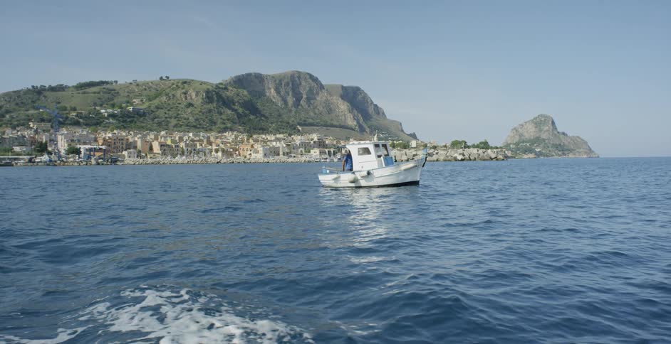 Small boat floats on the ocean near the shore