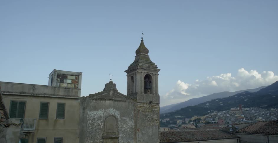 Dilapidated building near houses and mountains