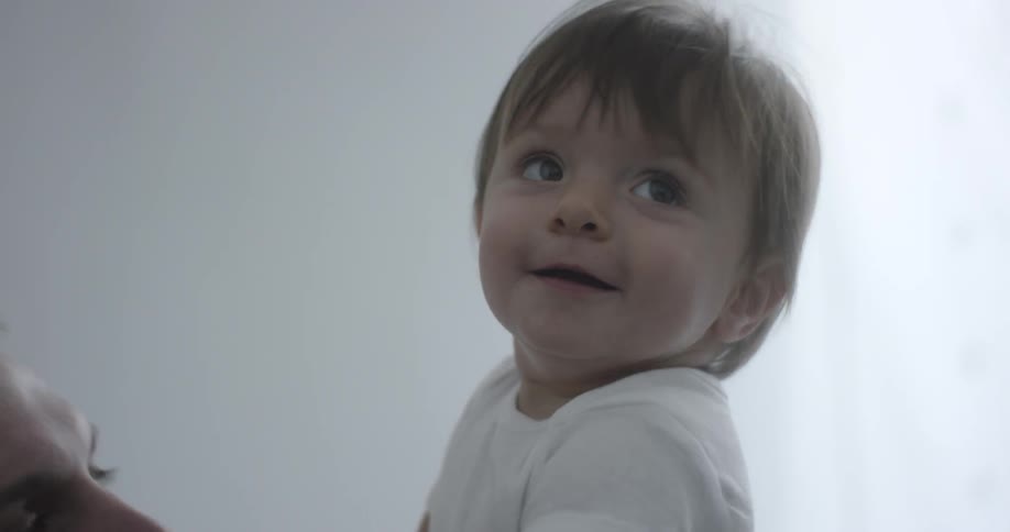 Man smiling and playing with baby in room