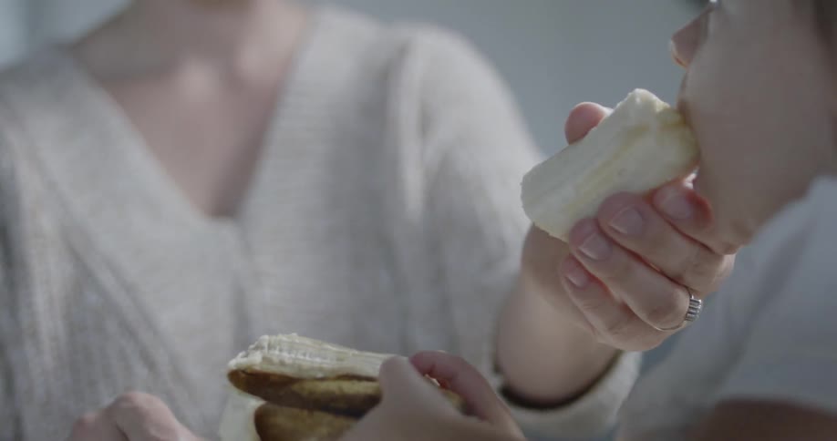Woman feeds banana to a baby