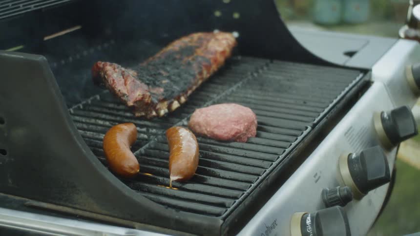 A person is cooking meat on a grill
