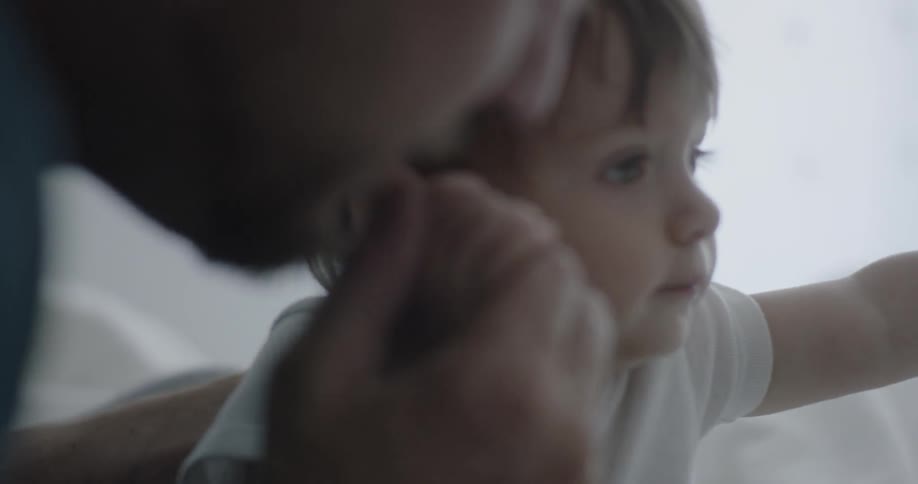 A man plays with a baby who smiles