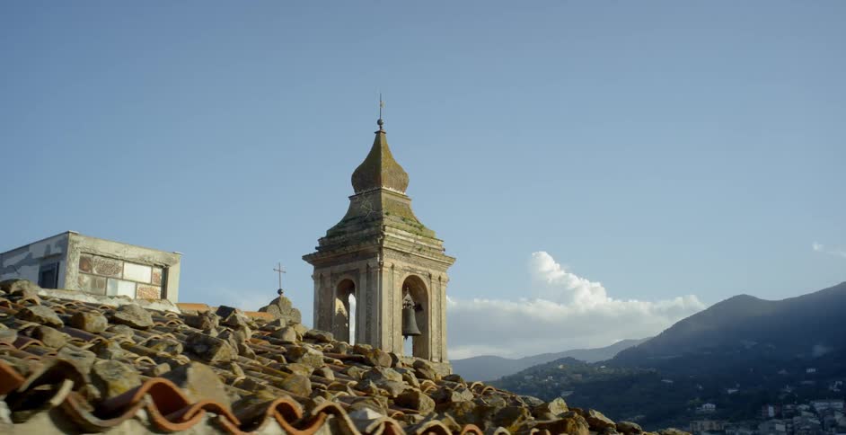 An old church bell tower is standing out against the sky on a sunny day