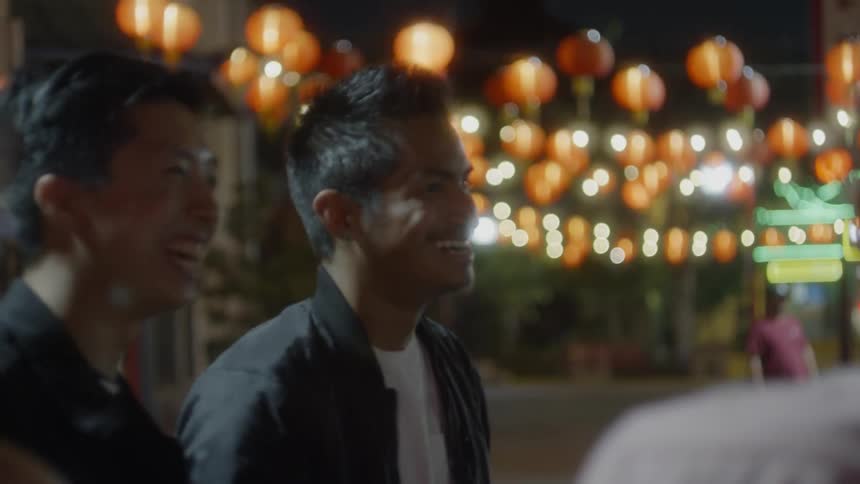 People stand outside at night in the street talking