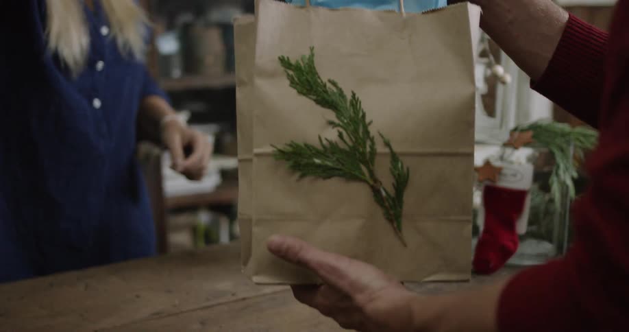 A woman bags an item and hands it off