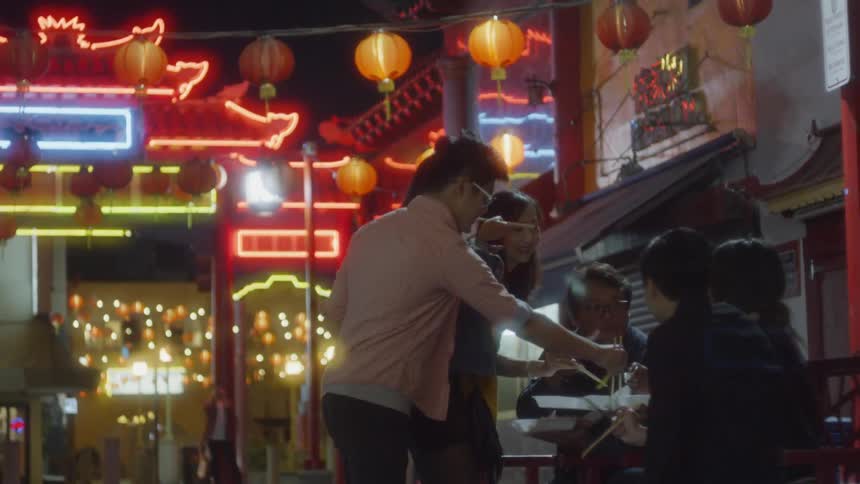 A group of people eat outside at night