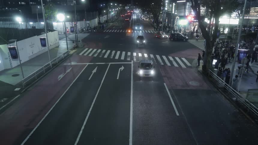 People cross the street at a city intersection at night
