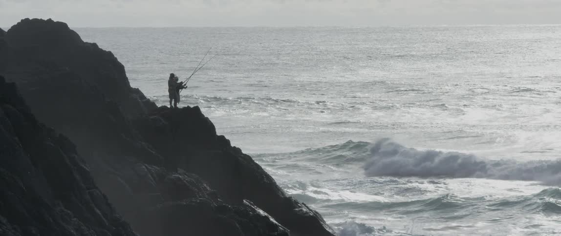 People are fishing in the waves