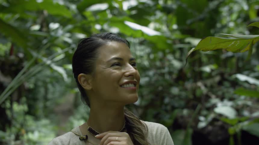 A woman smiles as she looks at the trees