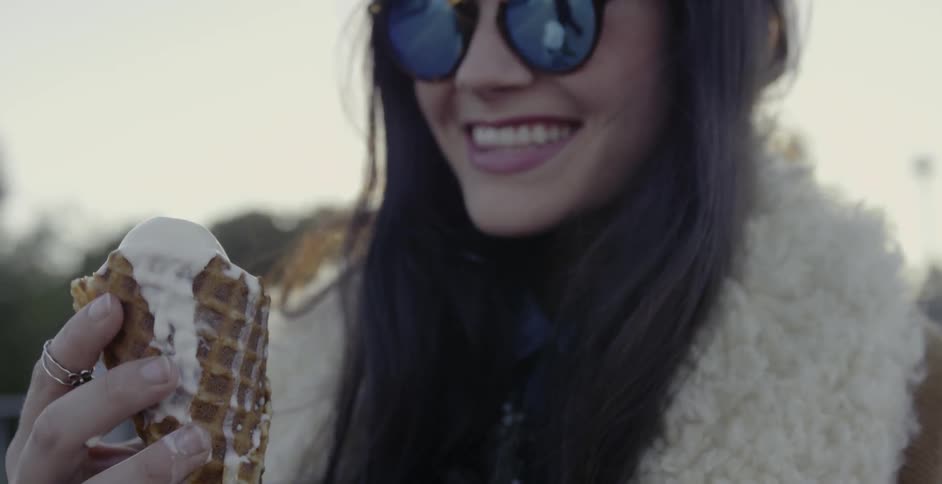 A woman is happy holding an ice cream cone
