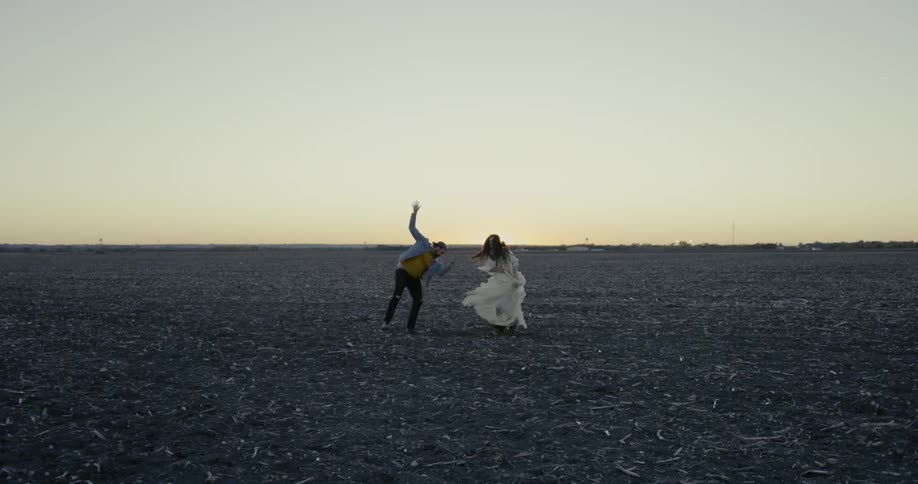 A couple dance on a black field