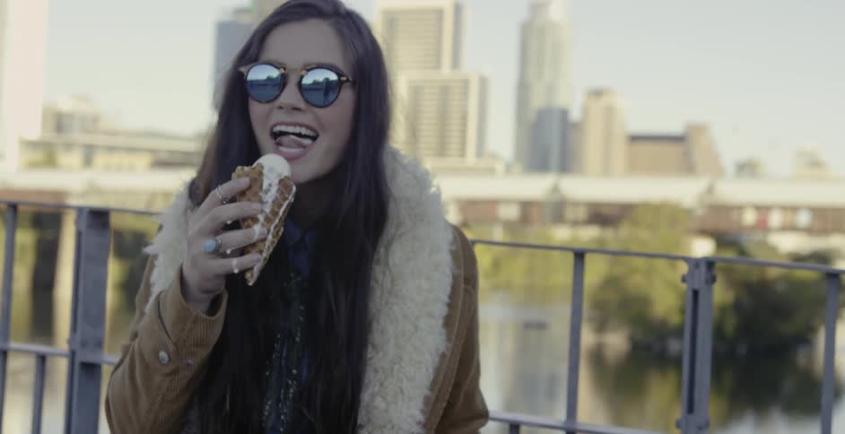 A woman licks a melting ice cream cone