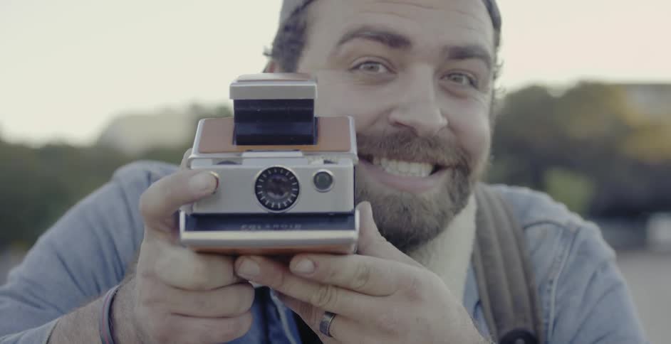 Man smiles and takes a picture