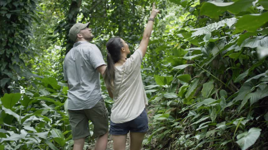 A woman points things out to her boyfriend as they walk hand in hand