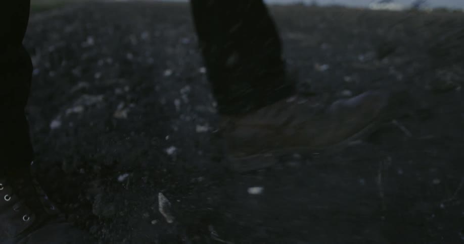 A person kicks dirt on the ground