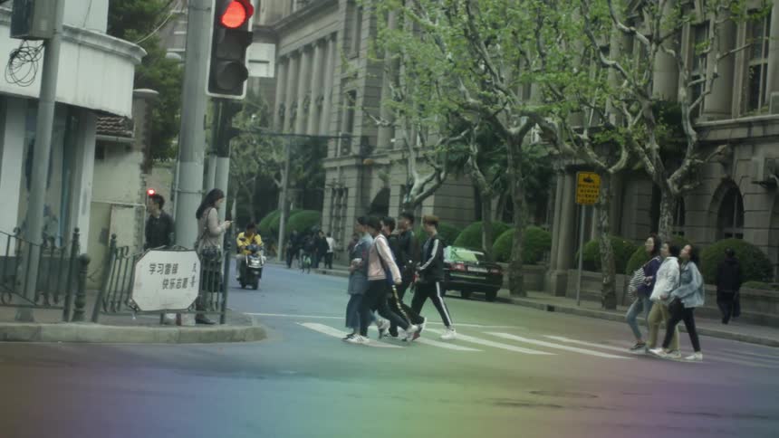 People walk in a crosswalk in a busy city