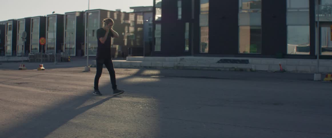 A man talks on his phone as he walks down the street