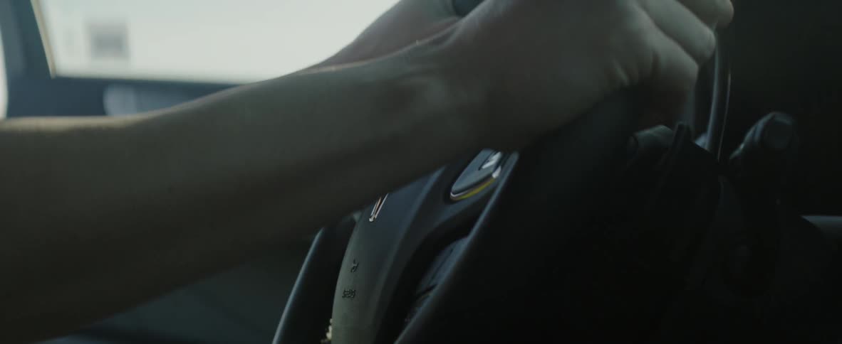 Person entering a vehicle and placing their hands on the steering wheel