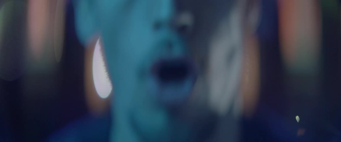 A distorted macro shot captures a frustrated male character screaming under neon lights.