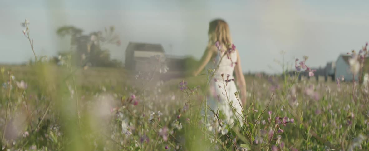 A woman walks through the tall grass