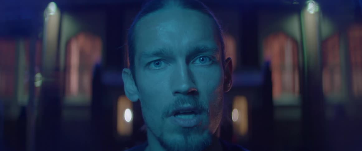 An angry young man shouts and yells furiously directly into the camera outside.
