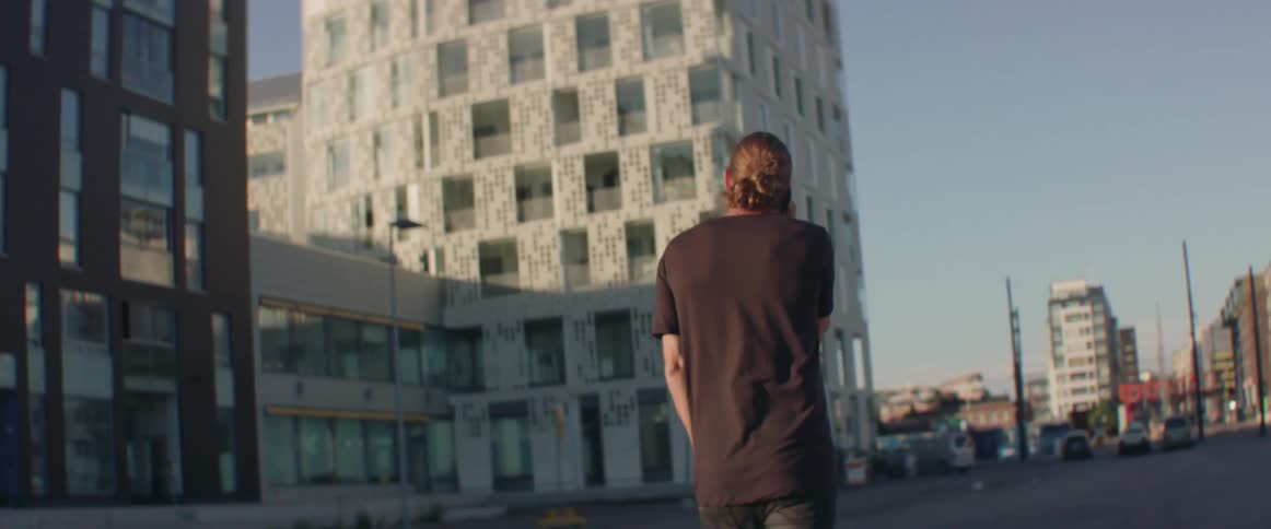 A man walks outside in the city while talking on the phone
