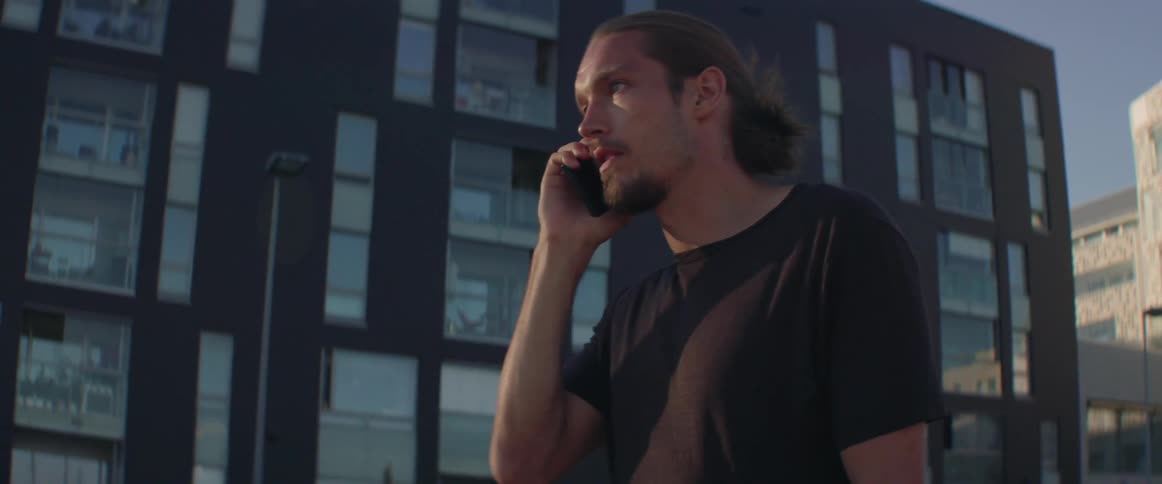 A man walks in a city while talking on the phone
