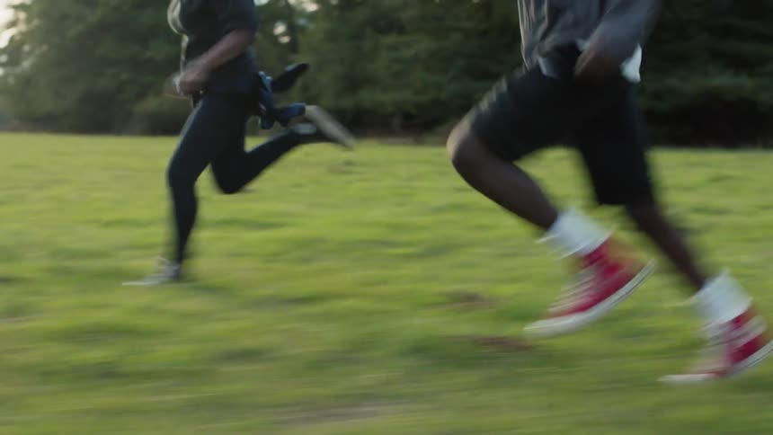 Two people are racing across the green field