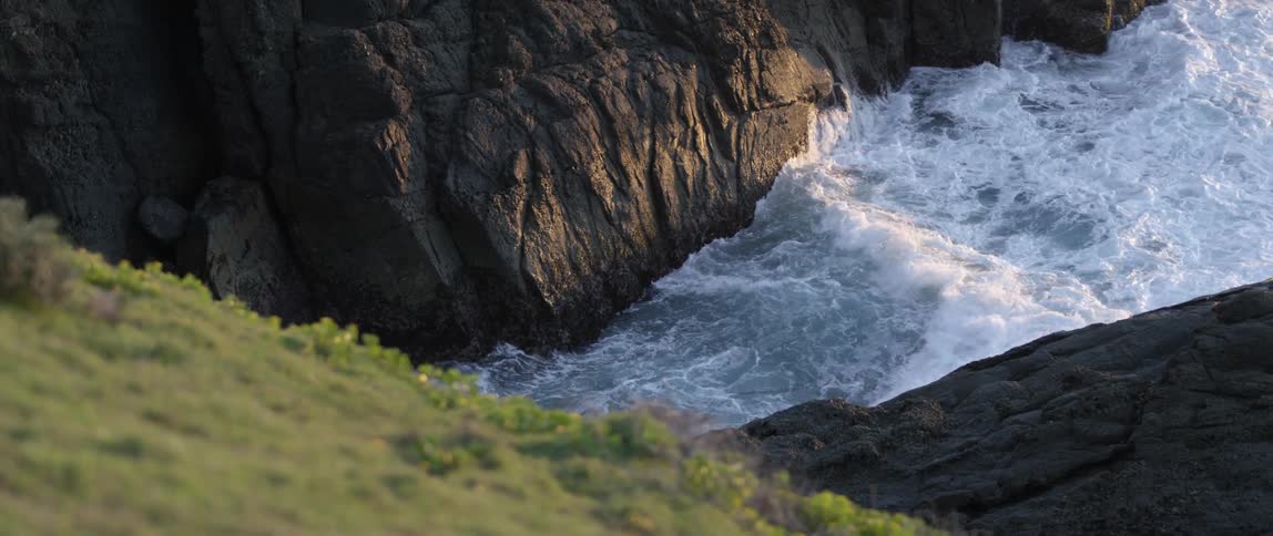 Waves washing into the base of a mountain