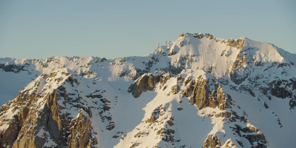 The mountains are covered with snow on a sunny day