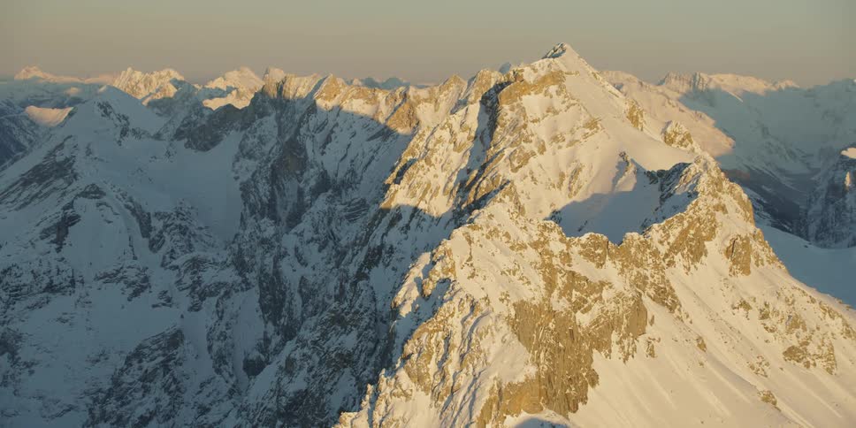 The sun shines on a snow covered mountain