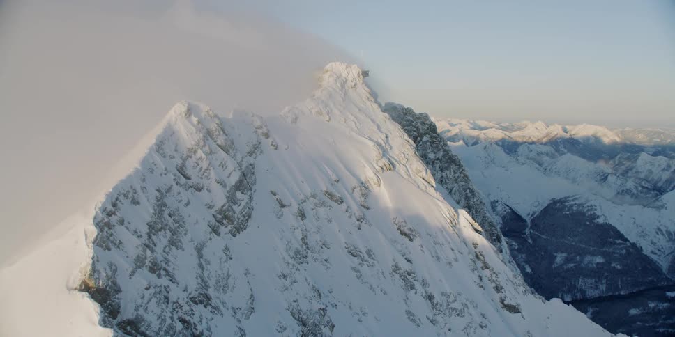 The clouds are rolling over the snow covered mountain