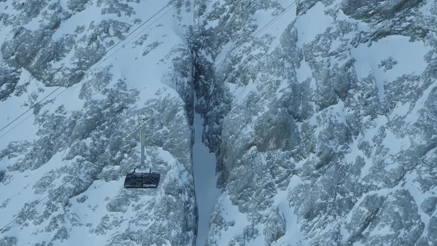 The ski lift is ascending up the mountain